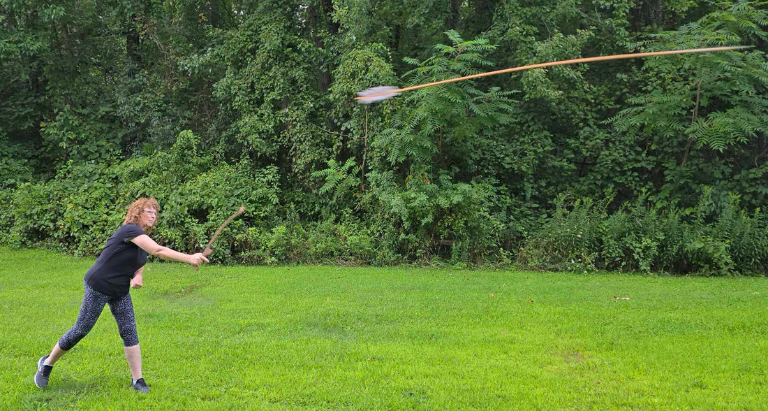 Woman demonstrating proper atlatl throwing technique with dart